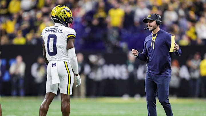 Michigan defensive coordinator Jesse Minter, right, talks to defensive back Mike Sainristil 