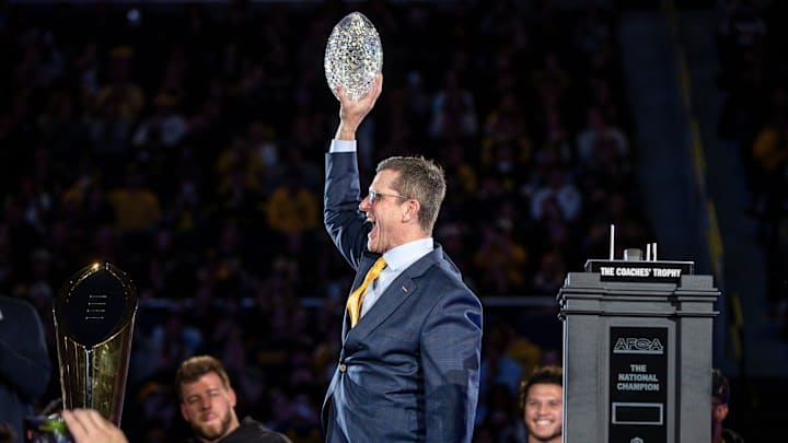 Jan 13, 2024; Ann Arbor, MI, USA; Michigan head coach Jim Harbaugh lifts the AFCA Coaches' Trophy during the national championship celebration at Crisler Center in Ann Arbor on Saturday, Jan. 13, 2024. Mandatory Credit: Junfu Han-Imagn Images