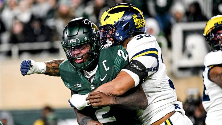 Michigan State's Aidan Chiles, left, is hit by Michigan's Dominic Nichols after throwing the ball during the third quarter on Saturday, Oct. 25, 2025, at Spartan Stadium in East Lansing.