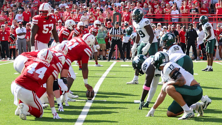 Nebraska and Michigan State linemen prepare for a play at Memorial Stadium.