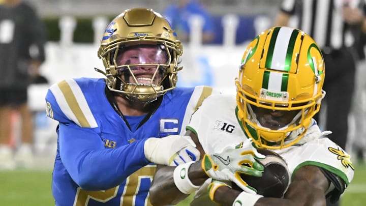 UCLA Bruins linebacker Kain Medrano (20) tackles Oregon Ducks wide receiver Evan Stewart.