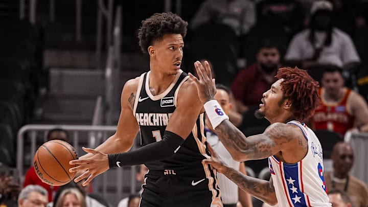 Mar 7, 2026; Atlanta, Georgia, USA; Atlanta Hawks forward Jalen Johnson (1) protects the ball against Philadelphia 76ers forward/guard Kelly Oubre Jr. (9) during the first half at State Farm Arena. Mandatory Credit: Dale Zanine-Imagn Images