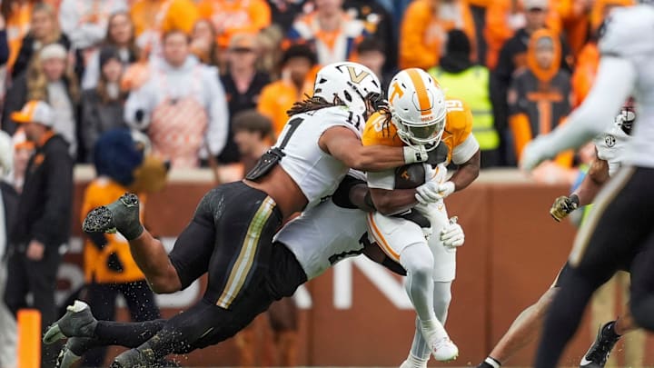 Vanderbilt linebacker Bryan Longwell (11) and Vanderbilt safety Marlen Sewell (7) tackle Tennessee running back Daune Morris (19) during a NCAA football game between Tennessee and Vanderbilt at Neyland Stadium in Knoxville, Tenn., on Nov. 29, 2025.