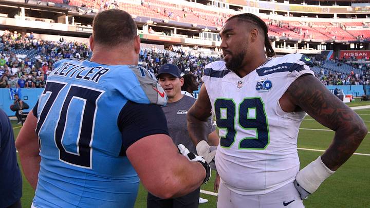 Nov 23, 2025; Nashville, Tennessee, USA; Tennessee Titans guard Kevin Zeitler (70) and Seattle Seahawks defensive end Leonard Williams (99) meet after a game at Nissan Stadium. Mandatory Credit: Steve Roberts-Imagn Images