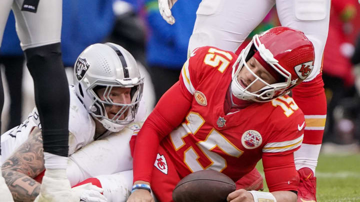 Dec 25, 2023; Kansas City, Missouri, USA; Kansas City Chiefs quarterback Patrick Mahomes (15) reacts after being sacked by Las Vegas Raiders defensive end Maxx Crosby (98) during the game at GEHA Field at Arrowhead Stadium. Mandatory Credit: Denny Medley-USA TODAY Sports