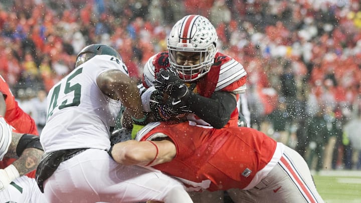 Nov 15, 2015; Columbus, OH, USA; Ohio State Buckeyes tight end Nick Vannett (81) blocks Michigan State Spartans linebacker Darien Harris (45) as Ohio State Buckeyes running back Ezekiel Elliott (15) scores over the top in the first half of their game at Value City Arena. Mandatory Credit: Greg Bartram-Imagn Images