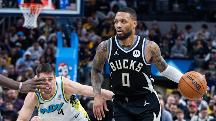 Dec 31, 2024; Indianapolis, Indiana, USA; Milwaukee Bucks guard Damian Lillard (0) dribbles the ball while Indiana Pacers guard T.J. McConnell (9) defends in the second half at Gainbridge Fieldhouse. Mandatory Credit: Trevor Ruszkowski-Imagn Images