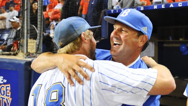 Jun 8, 2013; Fullerton, CA, USA; UCLA Bruins head coach John Savage (22) celebrates with second baseman Cody Regis (18) following a 3-0 win against the Cal State Fullerton Titans to win the Fullerton super regional of the 2013 NCAA baseball tournament at Goodwin Field. Mandatory Credit: Christopher Hanewinckel-Imagn Images Jun 8, 2013; Fullerton, CA, USA; UCLA Bruins head coach John Savage (22) celebrates with second baseman Cody Regis (18) following a 3-0 win against the Cal State Fullerton Titans to win the Fullerton super regional of the 2013 NCAA baseball tournament at Goodwin Field. Mandatory Credit: Christopher Hanewinckel-Imagn Images