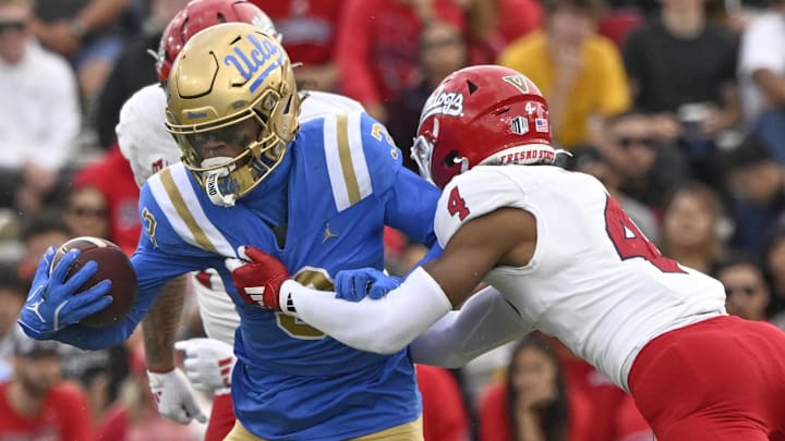 Nov 30, 2024; Pasadena, California, USA; UCLA Bruins wide receiver Kwazi Gilmer (3) tries to break free from Fresno State Bulldogs linebacker RL Miller (4) during the third quarter at Rose Bowl. Mandatory Credit: Robert Hanashiro-Imagn Images