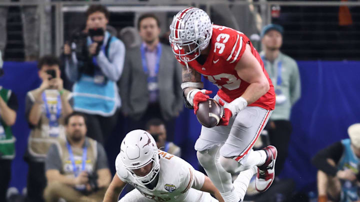 Jan 10, 2025; Arlington, Texas, USA; Ohio State Buckeyes defensive end Jack Sawyer (33) causes a fumble by Texas Longhorns quarterback Quinn Ewers (3) then returns the ball for a touchdown during the fourth quarter of the College Football Playoff semifinal in the Cotton Bowl at AT&T Stadium. Mandatory Credit: Tim Heitman-Imagn Images