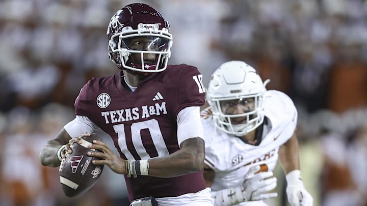 Nov 30, 2024; College Station, Texas, USA; Texas A&M Aggies quarterback Marcel Reed (10) looks for an open receiver as Texas Longhorns linebacker Trey Moore (8) defends during the fourth quarter at Kyle Field.