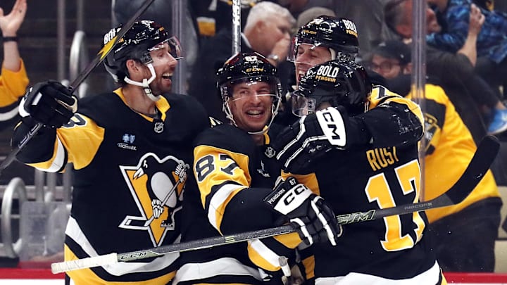 Oct 16, 2024; Pittsburgh, Pennsylvania, USA; Pittsburgh Penguins defenseman Marcus Pettersson (left), center Sidney Crosby (87), and right wing Bryan Rust (17) congratulate center Evgeni Malkin (71) on his 500th career NHL goal against the Buffalo Sabres during the third period at PPG Paints Arena.