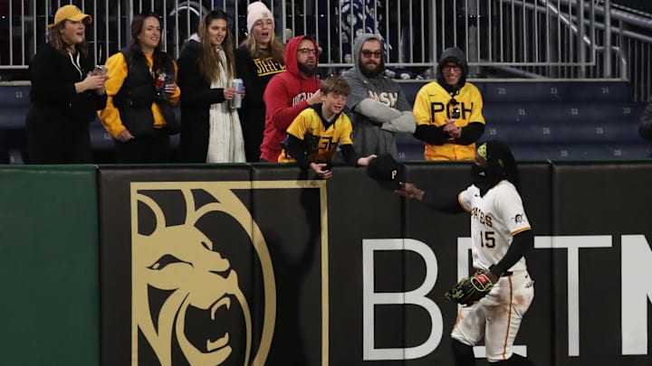 Apr 16, 2025; Pittsburgh, Pennsylvania, USA;  Pittsburgh Pirates center fielder Oneil Cruz (15) gives his game cap to a young fan after defeating the Washington Nationals at PNC Park. Mandatory Credit: Charles LeClaire-Imagn Images