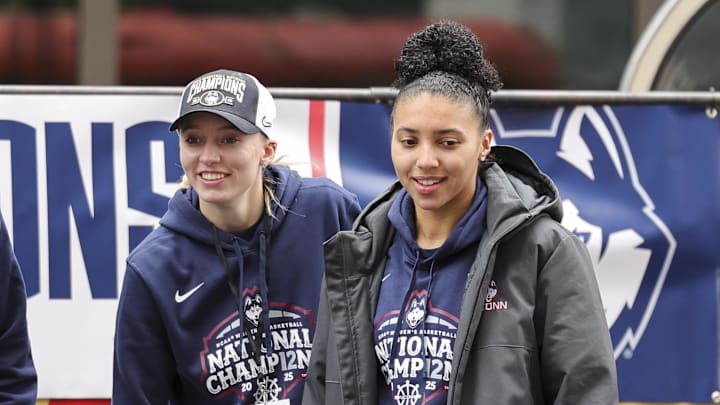Apr 13, 2025; Hartford, CT, USA;  UConn student-athlete Paige Bueckers and UConn student-athlete Azzi Fudd walk onto the stage during the Final Four Champions victory parade and rally outside of the XL Center in Hartford, CT. Mandatory Credit: Scott Rausenberger-Imagn Images