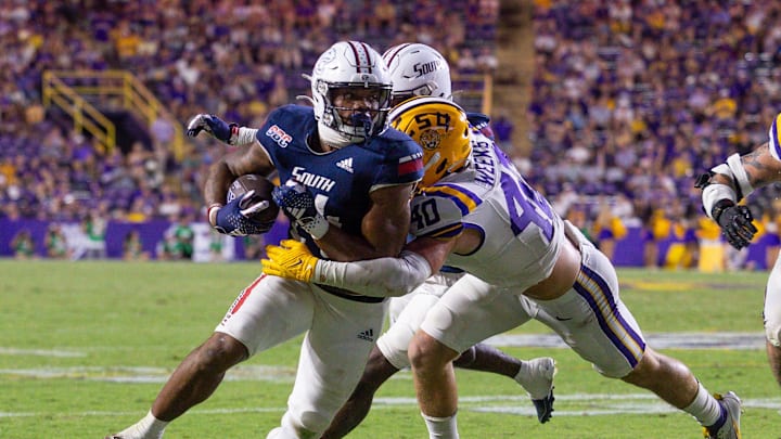 Sep 28, 2024; Baton Rouge, Louisiana, USA; South Alabama Jaguars running back Fluff Bothwell (24) is tackled by LSU Tigers linebacker Whit Weeks (40) during the second half at Tiger Stadium. Mandatory Credit: Stephen Lew-Imagn Images Sep 28, 2024; Baton Rouge, Louisiana, USA; South Alabama Jaguars running back Fluff Bothwell (24) is tackled by LSU Tigers linebacker Whit Weeks (40) during the second half at Tiger Stadium. Mandatory Credit: Stephen Lew-Imagn Images