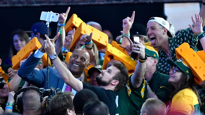 James Lofton poses for a selfie with Green Bay Packers fans during the second day of the NFL Draft
