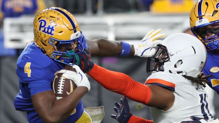 Nov 9, 2024; Pittsburgh, Pennsylvania, USA;  Pittsburgh Panthers running back Daniel Carter (4) carries the ball against Virginia Cavaliers defensive end Mekhi Buchanan (11) during the second quarter at Acrisure Stadium. Mandatory Credit: Charles LeClaire-Imagn Images