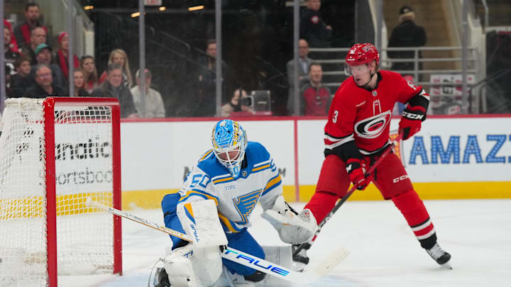 Mar 12, 2026; Raleigh, North Carolina, USA;  St. Louis Blues goaltender Jordan Binnington (50) stops the shot in front of Carolina Hurricanes right wing Jackson Blake (53) during the first period at Lenovo Center. Mandatory Credit: James Guillory-Imagn Images