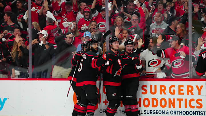 May 16, 2024; Raleigh, North Carolina, USA; Carolina Hurricanes center Martin Necas (88) celebrates his goal with defenseman Dmitry Orlov (7) and defenseman Jalen Chatfield (5) against the New York Rangers during the first period in game six of the second round of the 2024 Stanley Cup Playoffs at PNC Arena. Mandatory Credit: James Guillory-Imagn Images