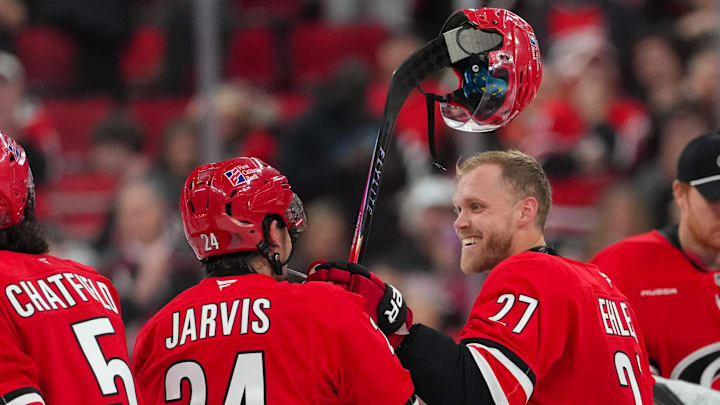 Nov 30, 2025; Raleigh, North Carolina, USA;  Carolina Hurricanes left wing Nikolaj Ehlers (27) and center Seth Jarvis (24) celebrate their victory against the Calgary Flames in the over time at Lenovo Center. Mandatory Credit: James Guillory-Imagn Images