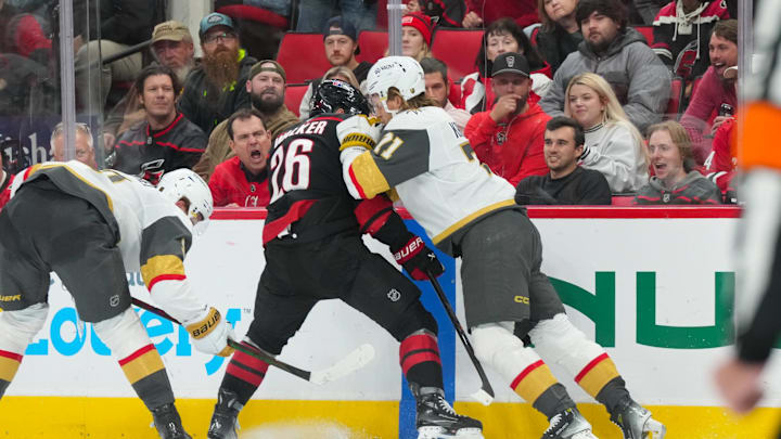 Oct 28, 2025; Raleigh, North Carolina, USA; Vegas Golden Knights center William Karlsson (71) checks Carolina Hurricanes defenseman Sean Walker (26) during the third periodat Lenovo Center. Mandatory Credit: James Guillory-Imagn Images