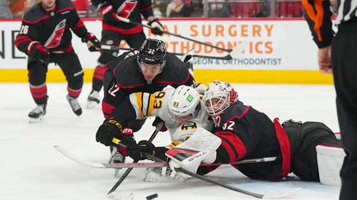 Apr 7, 2026; Raleigh, North Carolina, USA; Carolina Hurricanes goaltender Brandon Bussi (32) with center Logan Stankoven (22) and Boston Bruins center Fraser Minten (93) battle for the puck during the second period at Lenovo Center. Mandatory Credit: James Guillory-Imagn Images Apr 7, 2026; Raleigh, North Carolina, USA; Carolina Hurricanes goaltender Brandon Bussi (32) with center Logan Stankoven (22) and Boston Bruins center Fraser Minten (93) battle for the puck during the second period at Lenovo Center. Mandatory Credit: James Guillory-Imagn Images