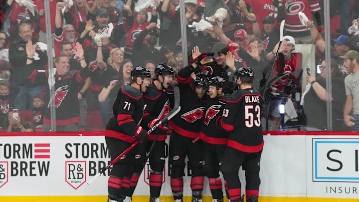 Apr 18, 2026; Raleigh, North Carolina, USA; Carolina Hurricanes left wing Taylor Hall (71) is congratulated by defenseman Alexander Nikishin (21)  defenseman Shayne Gostisbehere (4) center Logan Stankoven (22) and  right wing Jackson Blake (53) after his goal against the Ottawa Senators during the third period in game one of the first round of the 2026 Stanley Cup Playoffs at Lenovo Center. Mandatory Credit: James Guillory-Imagn Images