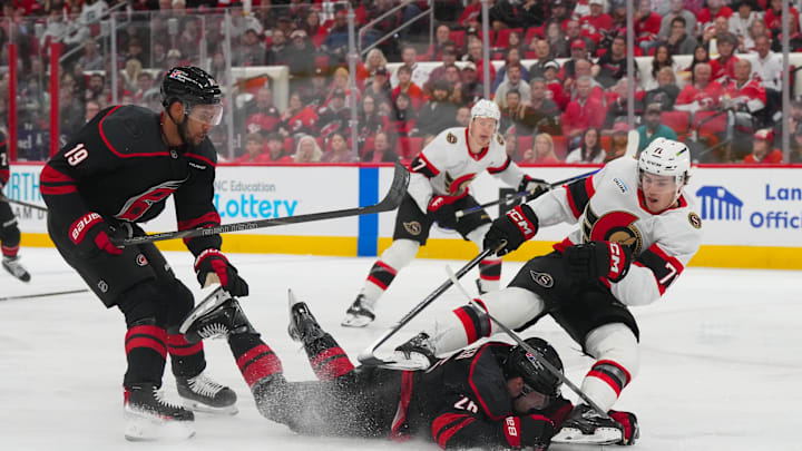 Apr 20, 2026; Raleigh, North Carolina, USA; Ottawa Senators center Ridly Greig (71) is tripped by Carolina Hurricanes defenseman Sean Walker (26) during the second period in game two of the first round of the 2026 Stanley Cup Playoffs at Lenovo Center. Mandatory Credit: James Guillory-Imagn Images