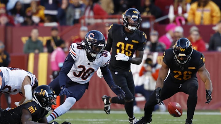 Current Bears and former Commanders wide receiver Olamide Zaccheaus (14) recovers a fumble in front of former Bears safety Tarvarius Moore.