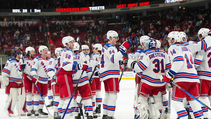 Nov 26, 2025; Raleigh, North Carolina, USA; New York Rangers players celebrate the win against the Carolina Hurricanes at Lenovo Center. Mandatory Credit: James Guillory-Imagn Images
