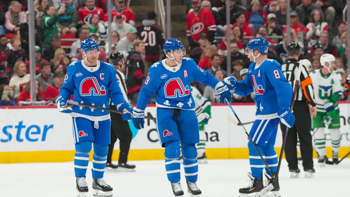 Jan 3, 2026; Raleigh, North Carolina, USA; Colorado Avalanche center Nathan MacKinnon (29) celebrates after scoring an empty net goal with defenseman Cale Makar (8) and left wing Gabriel Landeskog (92) against the Carolina Hurricanes during the third period at Lenovo Center. Mandatory Credit: James Guillory-Imagn Images