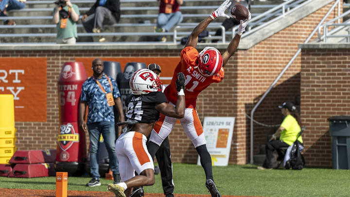 Jan 29, 2025; Mobile, AL, USA; American team wide receiver Arian Smith of Georgia (11) leaps for a completion over American team defensive back Upton Stout of Western Kentucky (24) during Senior Bowl practice for the National team at Hancock Whitney Stadium. 