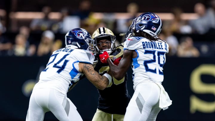 Aug 25, 2024; New Orleans, Louisiana, USA;  New Orleans Saints cornerback Rejzohn Wright (28) is blocked on a kick off by Tennessee Titans cornerback Elijah Molden (24) and cornerback Jarvis Brownlee Jr. (29) during the first half at Caesars Superdome. Mandatory Credit: Stephen Lew-USA TODAY Sports