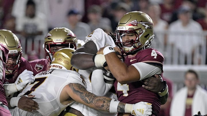 Sep 2, 2024; Tallahassee, Florida, USA; Florida State Seminoles quarterback DJ Uiagalelei (4) is tackled against the Boston College Eagles at Doak S. Campbell Stadium. Mandatory Credit: Melina Myers-Imagn Images