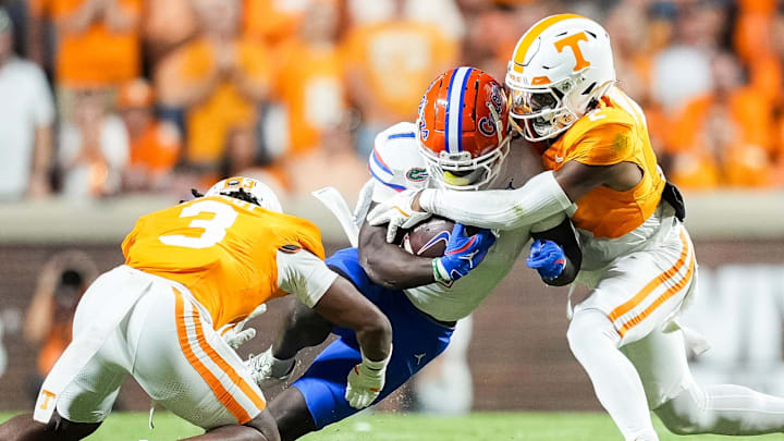 Tennessee defensive back Andre Turrentine (2) and defensive back Jermod McCoy (3) tackle Florida running back Montrell Johnson Jr. (1) during a SEC conference game between Tennessee and Florida in Neyland Stadium on Saturday, Oct. 12, 2024.