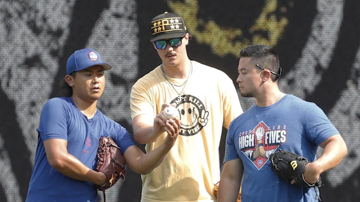 Aug 27, 2024; Pittsburgh, Pennsylvania, USA; Chicago Cubs pitcher Shota Imanaga (left) and Pittsburgh Pirates pitcher Paul Skenes (middle) discuss pitching grips as Edwin Stanberry (right) interprets before the Pirates host the Cubs at PNC Park.