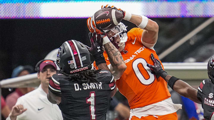 Aug 31, 2025; Atlanta, Georgia, USA; Virginia Tech Hokies wide receiver Ayden Greene (0) tries for a catch over South Carolina Gamecocks defensive back DQ Smith (1) during the first half at Mercedes-Benz Stadium. Mandatory Credit: Dale Zanine-Imagn Images