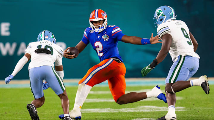 Florida Gators quarterback DJ Lagway (2) eludes Tulane Green Wave defensive back Lu Tillery (10) and Tulane Green Wave linebacker Terrell Allen (9) during the second half at Raymond James Stadium in Tampa, FL on Friday, December 20, 2024 in the 2024 Union Home Mortgage Gasparilla Bowl. The Gators defeated Tulane 33-8. [Doug Engle/Gainesville Sun]