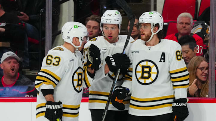 Apr 4, 2024; Raleigh, North Carolina, USA; Boston Bruins left wing Brad Marchand (63) defenseman Charlie McAvoy (73) and right wing David Pastrnak (88) talk against the Carolina Hurricanes during the second period at PNC Arena. Mandatory Credit: James Guillory-USA TODAY Sports