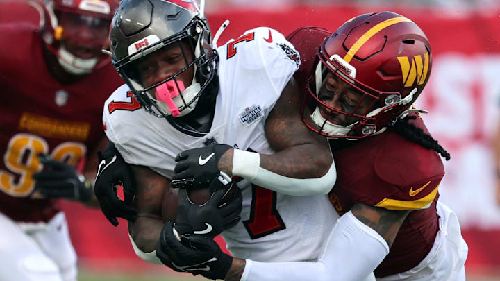 Sep 8, 2024; Tampa, Florida, USA;  Tampa Bay Buccaneers running back Bucky Irving (7) runs with the ball as Washington Commanders linebacker Frankie Luvu (4) tackles during the second half at Raymond James Stadium. 