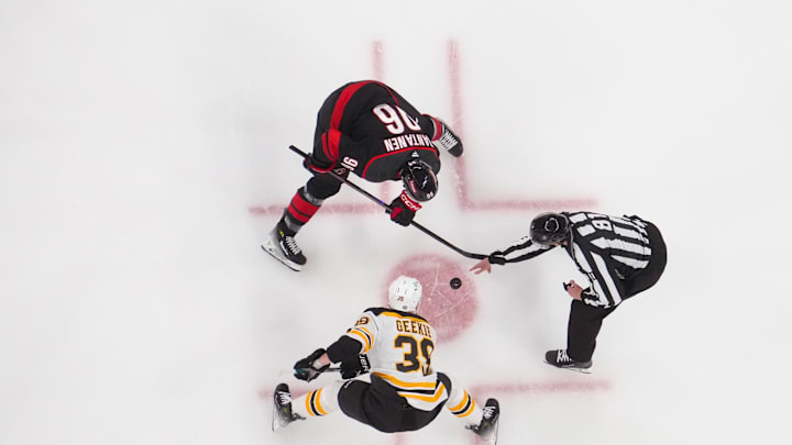 Mar 6, 2025; Raleigh, North Carolina, USA;  Carolina Hurricanes right wing Mikko Rantanen (96) and Boston Bruins center Morgan Geekie (39) take a face off during the first period at Lenovo Center. Mandatory Credit: James Guillory-Imagn Images