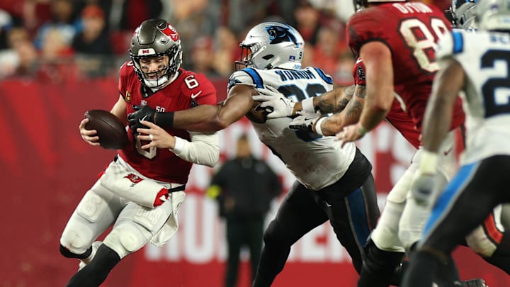 Jan 3, 2026; Tampa, Florida, USA; Tampa Bay Buccaneers quarterback Baker Mayfield (6) runs against Carolina Panthers linebacker D.J. Wonnum (98) in the second half at Raymond James Stadium. Mandatory Credit: Nathan Ray Seebeck-Imagn Images