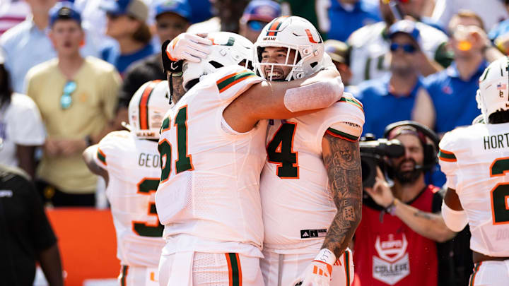 Aug 31, 2024; Gainesville, Florida, USA; Miami Hurricanes tight end Cam McCormick (84) celebrate with offensive lineman Francis Mauigoa (61) after scoring a touchdown against the Florida Gators during the first half at Ben Hill Griffin Stadium. Mandatory Credit: Matt Pendleton-Imagn Images