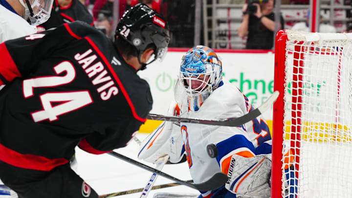 Mar 30, 2025; Raleigh, North Carolina, USA;  Carolina Hurricanes center Seth Jarvis (24) scores a goal past New York Islanders goaltender Marcus Hogberg (50) during the third period at Lenovo Center. Mandatory Credit: James Guillory-Imagn Images