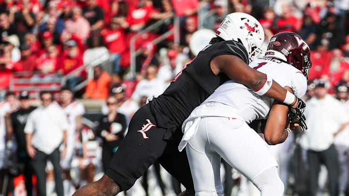 Louisville Cardinals defensive lineman Ramon Puryear (41) sacks Virginia Tech Hokies quarterback Kyron Drones (1) as the Cards went up against Virginia Tech Saturday in the second quarter. Nov.4, 2023.