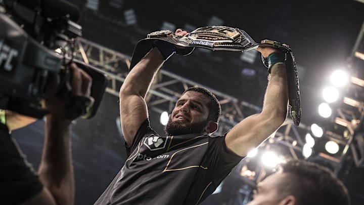 Oct 22, 2022; Abu Dhabi, UAE;   Islam Makhachev (blue gloves) celebrates with the title belt after