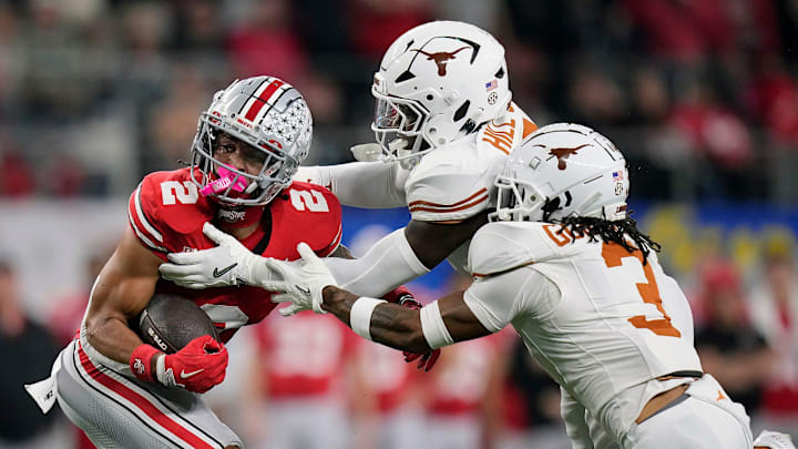 Ohio State Buckeyes wide receiver Emeka Egbuka (2) makes a catch against Texas Longhorns defensive back Jaylon Guilbeau (3) and linebacker Anthony Hill Jr. (0) in the first quarter of the Cotton Bowl Classic during the College Football Playoff semifinal game at AT&T Stadium in Arlington, Texas on January, 10, 2025.