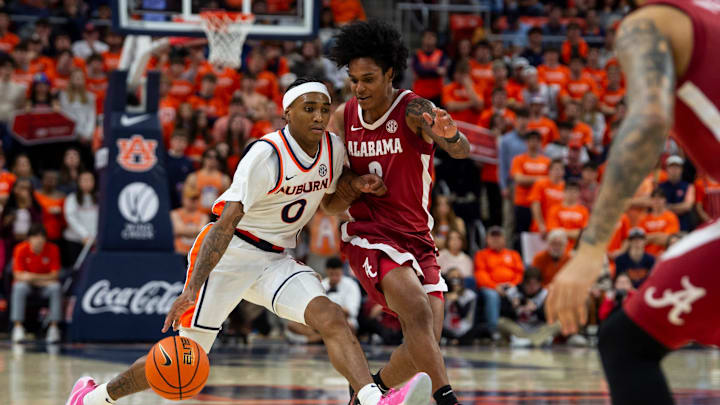 Auburn Tigers guard Tahaad Pettiford (0) drives the ball on Alabama Crimson Tide guard Aden Holloway (2) as Auburn Tigers take on Alabama Crimson Tide at Neville Arena in Auburn, Ala. on Saturday, Feb. 7, 2026. Alabama Crimson Tide defeated Auburn Tigers 96-92.