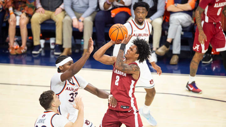Alabama Crimson Tide guard Aden Holloway (2) goes up for a layup over Auburn Tigers forward Sebastian Williams-Adams (33) as Auburn Tigers take on Alabama Crimson Tide at Neville Arena in Auburn, Ala. on Saturday, Feb. 7, 2026. Auburn Tigers lead Alabama Crimson Tide 41-37 at halftime.
