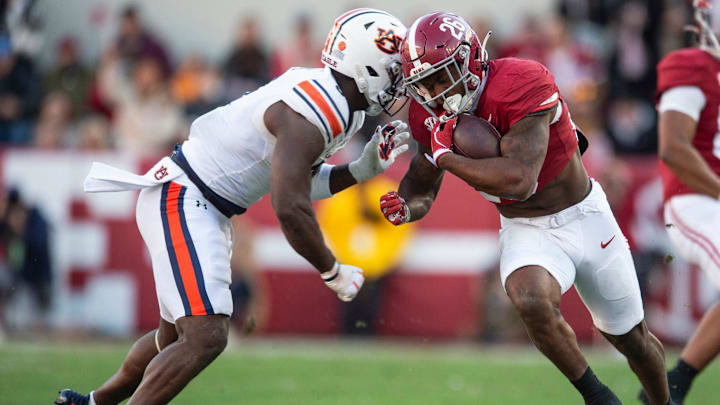 Alabama Crimson Tide running back Jam Miller (26) runs the ball and is forced out of bounds by Auburn Tigers linebacker Austin Keys (6) as Auburn Tigers take on Alabama Crimson Tide at Bryant-Denny Stadium in Tuscaloosa, Ala., on Saturday, Nov. 30, 2024. Alabama Crimson Tide leads Auburn Tigers 14-6 at halftime.
